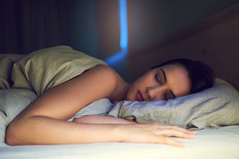Shot of a young woman sound asleep in her bedroom.