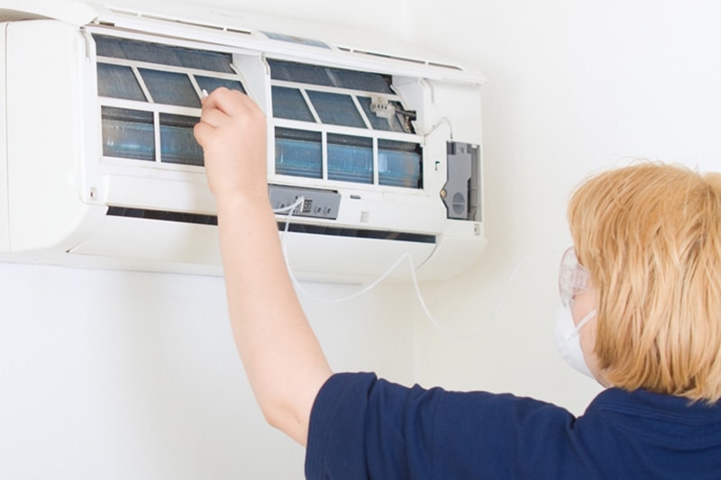 woman fixing a ductless system.